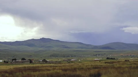 Panoramic View Of The Grassy Valley, Mountain Range And Village In The Distance Stock Footage 171903959