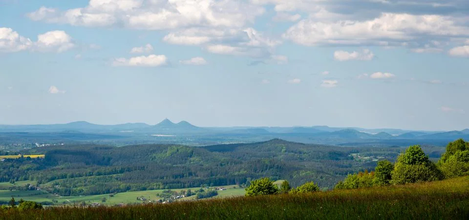 Panoramic view of green fields and forested hills near Jested, with the sha.. Stock Photos