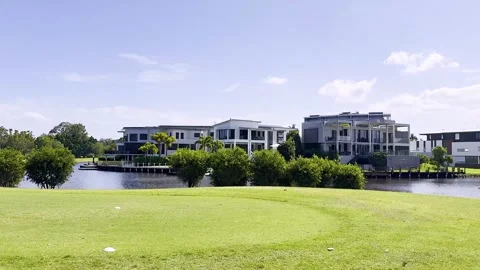 Panoramic view of green golf course and luxury waterfront residential build.. Stock-Footage 332587974