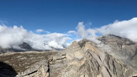 Panoramic View of High Mountain Ridge and Rolling Clouds Against a Blue Sky in Stock Footage 335984720
