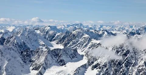 Panoramic view from a high point on the snow-covered mountain range. Mountain Stock Photos