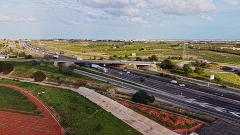 Panoramic view of a highway crossing through green valley Stock Footage 338221080