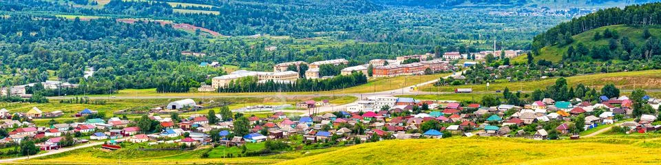 Panoramic view from hill to plain with small town in summer cloudy day. Pictu Stock Photos