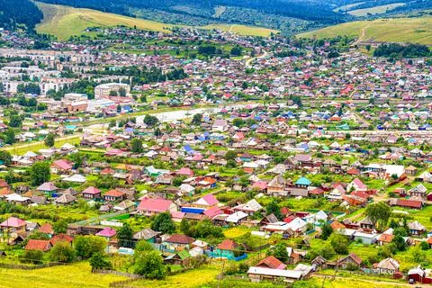 Panoramic view from hill to plain with small town in summer cloudy day. Pictu Stock Photos