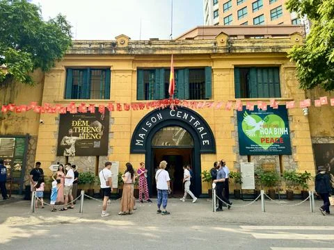 Panoramic view of Hoa Lo Prison facade with Maison Centrale sign and tourists Stock Photos