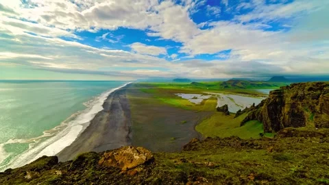 Panoramic view of icelandic black sand beach meeting green coastal cliffs Stock Footage 343695711