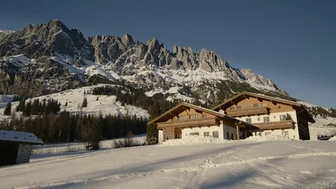 Panoramic view of idyllic winter wonderland with mountain tops and traditional m Stock Footage 74143274