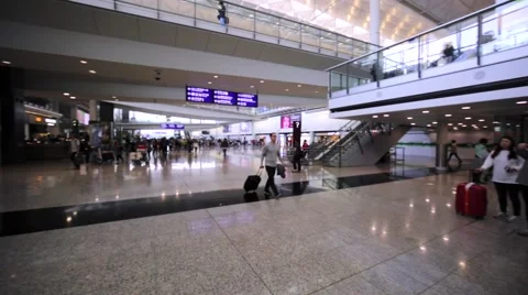 Panoramic view of interior of Hong Kong airport with many passengers all around Stock Footage