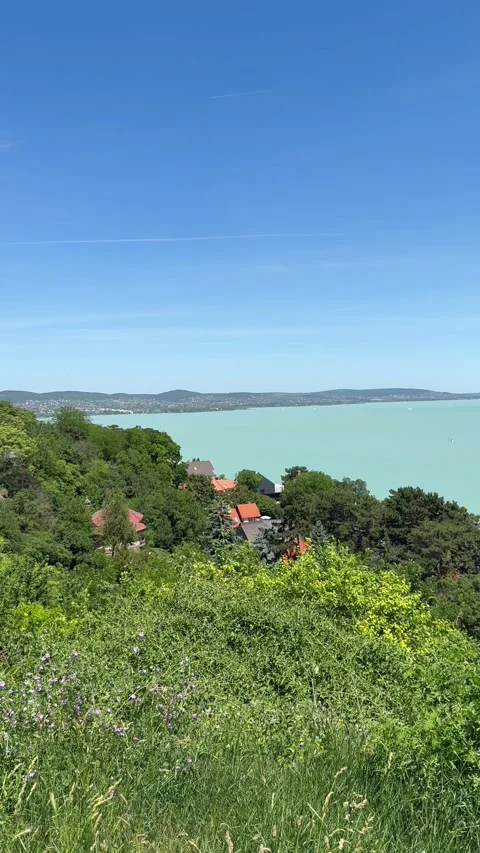 Panoramic view of Lake Balaton with hillside village and blue sky. The video rep Stock Footage 337782096