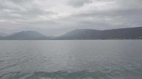 Panoramic view from a lake with distant mountains, gray sky, cloudy, 4K, Log Stock Footage 240935811