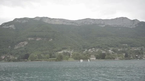 Panoramic view of a lake with mountains under gray sky, 4K, Log Stock Footage 240936050