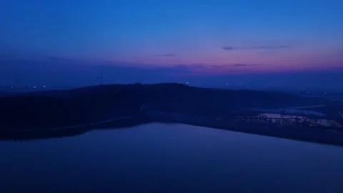 Panoramic View of a Lake Reflecting Twilight Sky and Wind Turbines China Stock Footage 338313512