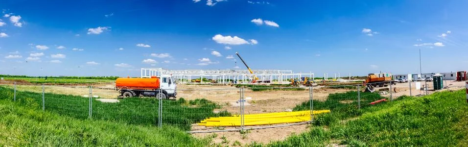 Panoramic view on landscape transform into urban area with machinery, people Stock Photos