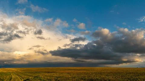 Panoramic view of a large rain cloud and an agricultural field. A huge cloud  Foto stock