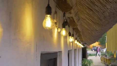 Panoramic view of lightbulbs on the side of a barn house shot in slow motion Stock Footage 229410609