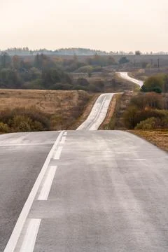 Panoramic view of a long empty asphalt road in a hilly area. The empty wind.. 写真素材