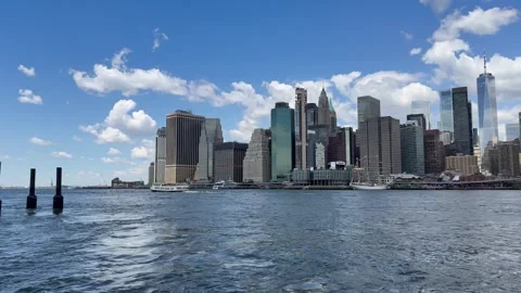 Panoramic view of Lower Manhattan. Ferry sails through East River. New York City Stock Footage 337837879