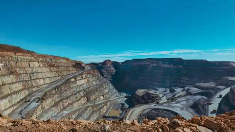 Panoramic view of the main pit of an open pit mine with machinery extractin.. Stock Photos