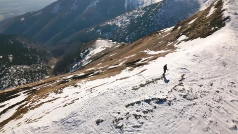 Panoramic view of man ski touring with dogs along Alpine ridge in early spring Stock Footage 307706913
