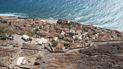 Panoramic view of medieval Monemvasia ruins above rough sea coastline Greece Stock Footage 344094614