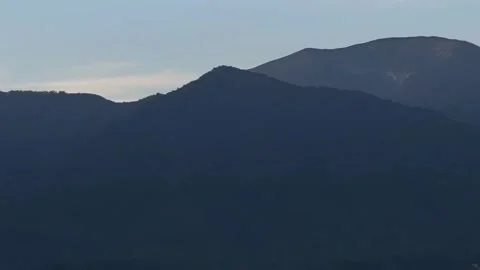 Panoramic View of Mist-Covered Mountain Valley Town at Dawn Stock Footage 339725983