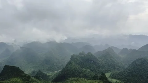 Panoramic View of Misty Green Karst Mountains Under Cloudy Sky Video stock 335578900
