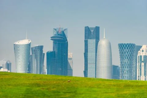 Panoramic view of modern skyline of Doha with green grass foreground. Concept of Stock Photos