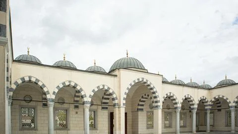 Panoramic view of mosque courtyard with arched gallery, grey and white stri.. Foto stock