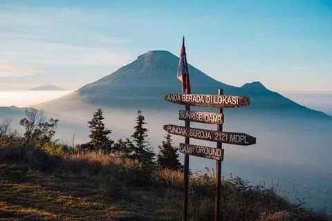 A panoramic view of Mount Sindoro set against a golden-blue sky at sunrise Photos