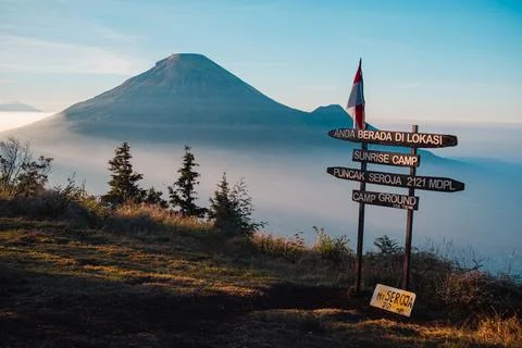 A panoramic view of Mount Sindoro set against a golden-blue sky at sunrise Photos