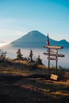 A panoramic view of Mount Sindoro set against a golden-blue sky at sunrise Photos