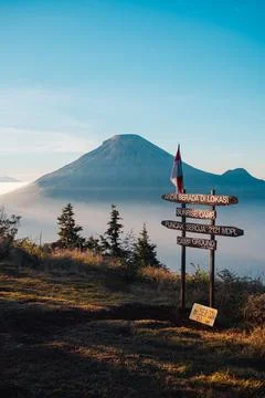 A panoramic view of Mount Sindoro set against a golden-blue sky at sunrise Photos