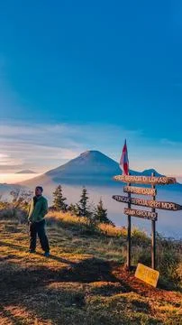 A panoramic view of Mount Sindoro set against a golden-blue sky at sunrise Photos