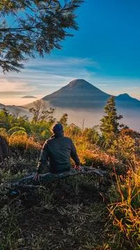 A panoramic view of Mount Sindoro set against a golden-blue sky at sunrise Photos