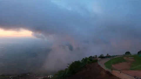 A panoramic view of a mountain with dense fog rolling in, partially obscuri.. Stock Footage 278239136