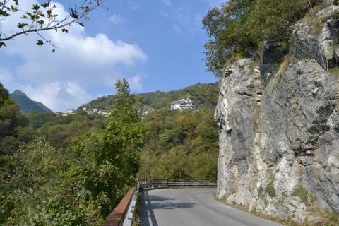 Panoramic view to a mountain large asphalt road in a sunny summer day. Stock Photos