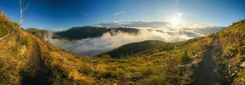 A panoramic view of a mountain range with a cloudy sky Stock Photos