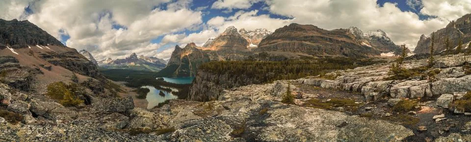 A panoramic view of a mountain range with a lake in the foreground Stock Photos