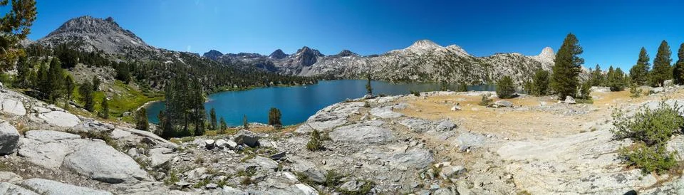 A panoramic view of a mountain range with a lake in the middle Stock Photos