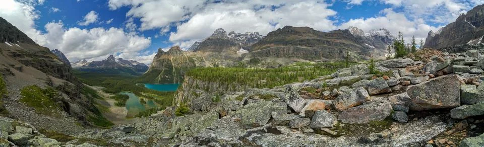 A panoramic view of a mountain range with a lake in the foreground Stock Photos
