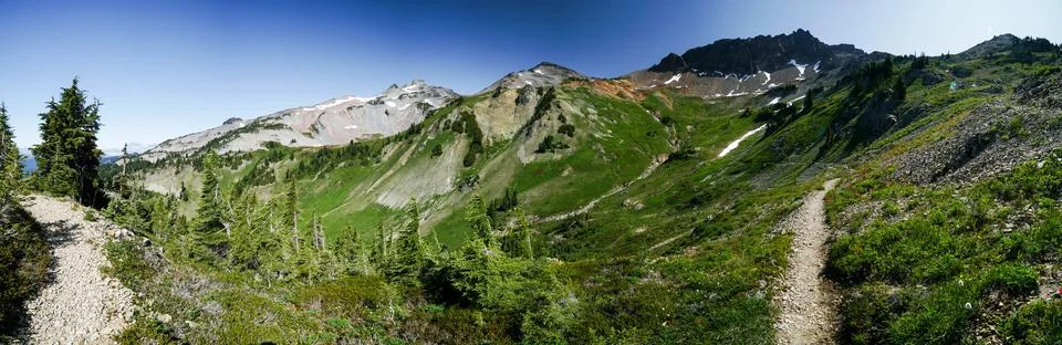 A panoramic view of a mountain range with a path leading up to it Foto stock