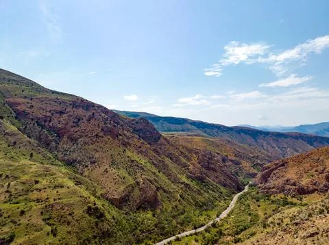 Panoramic view of mountain range with road snaking through valley Stock Photos