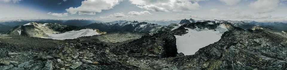 A panoramic view of a mountain range with snow-covered peaks Stock Photos