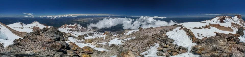 A panoramic view of a mountain range with snow-covered peaks Stock Photos