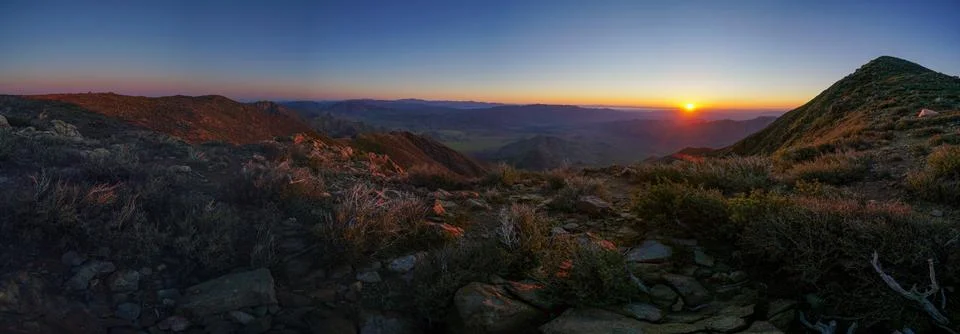 A panoramic view of a mountain range with a sunset in the background Stock Photos