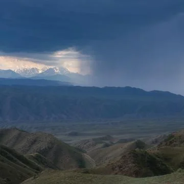 Panoramic view of a mountain range under dark storm clouds with dramatic sunl Foto stock