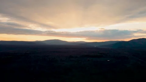 Panoramic view of mountain valley at sunset with golden sunbeams and dramatic Stock Footage 347039601