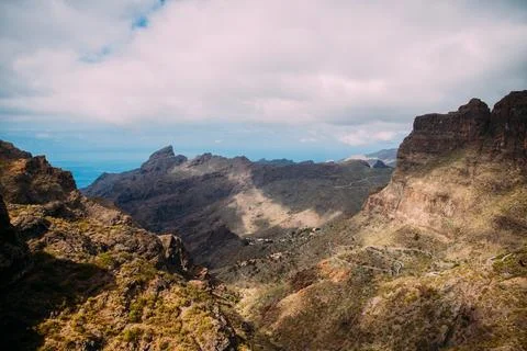 Panoramic view of mountainous landscape with winding road and distant ocean.. Stock Photos