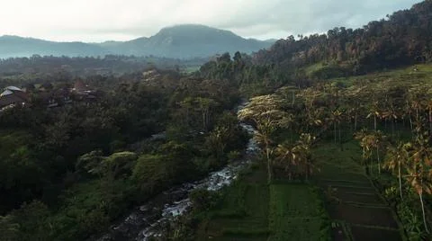 Panoramic view of mountains and forests surrounding a waterfall flowing from  Stock Photos