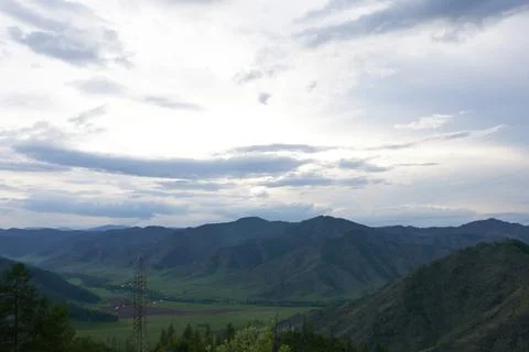 Panoramic view of the mountains in the evening in variable weather. Stock Photos